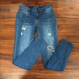 Light wash jeans with camo patches behind the rips